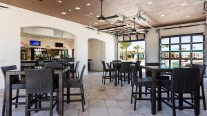 a dining room with tables and chairs and a bar at Windsor At Westside Superpower 8801 in Kissimmee