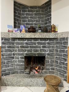 a brick fireplace with a fire in it at Pakha Dhim Heritage Homestay in Namchi +25 photos