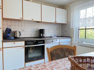 eine Küche mit weißen Schränken und einem Backofen in der Unterkunft Ferienhaus Wieke in Wiesmoor