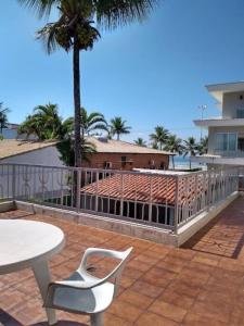 a white table and a chair on a patio at Casa 50m da praia - Enseada/Guarujá in Guarujá