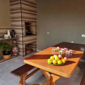 a wooden table with a bowl of fruit on it at Casa 50m da praia - Enseada/Guarujá in Guarujá