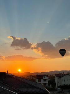 a hot air balloon flying over a city at sunset at Apart Angel Suit 5 in Nevsehir
