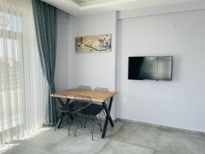 a dining room table with two chairs and a television on a wall at Apart Angel Suit 5 in Nevsehir