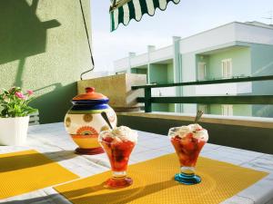 ガリポリにあるRobinia Apartment - Gallipolitravelのアイスクリーム三杯と花瓶付きテーブル