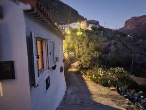 a building with a window on the side of it at Casa Rural LOS PINARES El Juncal de TEJEDA in Tejeda