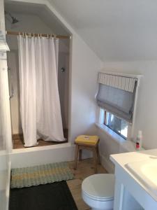 a white bathroom with a toilet and a window at Marston House Wiscasset in Wiscasset