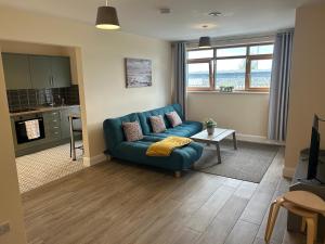 sala de estar con sofá azul y cocina en Privately gated apartments (x2), en Dublín