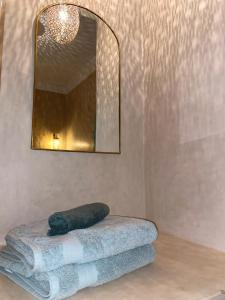 ein Stapel Handtücher auf einem Tisch unter einem Spiegel in der Unterkunft Riad with Outdoor Swimming Pools in Marrakesch
