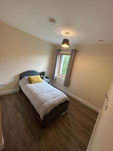 Habitación pequeña con cama y ventana en Privately gated apartments (x2), en Dublín