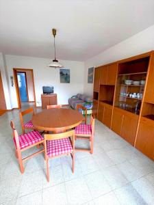 シローロにあるGIULY - appartamenti con terrazzo in centro a Siroloのリビングルーム(木製テーブル、椅子付)