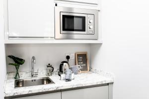 a kitchen counter with a sink and a microwave at Stay Coastal in Whitley Bay