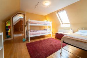 1 dormitorio con 2 literas y alfombra roja en Brosnan's Cottage, en Dingle