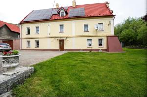 a large house with solar panels on its roof at Apartament w Dworku pod Twierdzą in Kłodzko