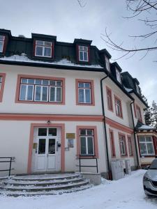 a large white building with red trim at Apartmán Vierka in Vysoké Tatry