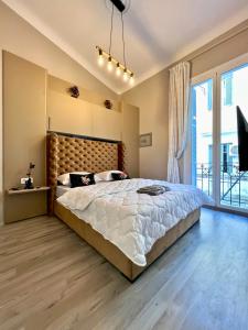 um quarto com uma cama grande e uma janela grande em Le Parisien - Chic 2BR City Centre Escape em Tânger
