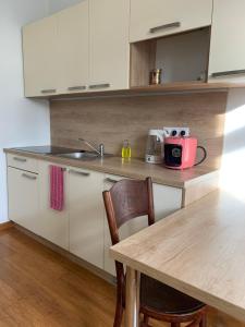 a kitchen with a wooden table and a counter top at Apartmán Vierka in Vysoké Tatry