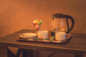 uma bandeja com uma cafeteira e chávenas numa mesa em Passage Art Hotel em Baku