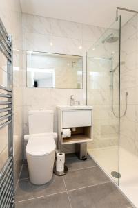 a bathroom with a toilet and a sink and a shower at Stay Coastal in Whitley Bay
