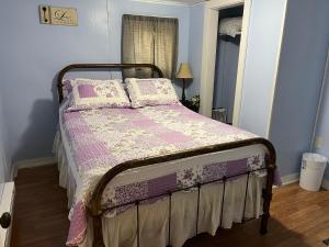 a bedroom with a bed with a pink blanket and pillows at Cochran Farm House in Bryson City
