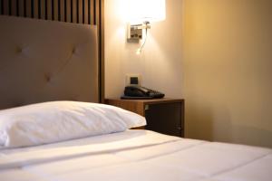 um quarto com uma cama e um telefone numa mesa em Hotel La Fertè em Asti