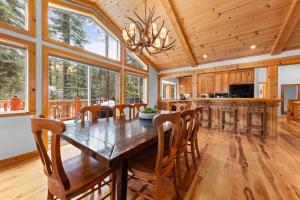 a dining room with a large wooden table and chairs at Tahoe Grand on the West Shore - Pet Friendly & Hot Tub! in Homewood