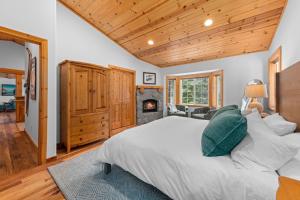 a bedroom with a large bed and a fireplace at Tahoe Grand on the West Shore - Pet Friendly & Hot Tub! in Homewood