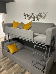 a loft bed with yellow pillows on it at Overwave Apartment in Kavála