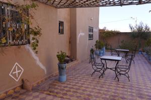 an outdoor patio with tables and chairs on a building at CHEZ MANAR in Ouarzazate