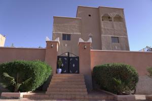 un edificio con una puerta y escaleras delante en CHEZ MANAR, en Ouarzazate