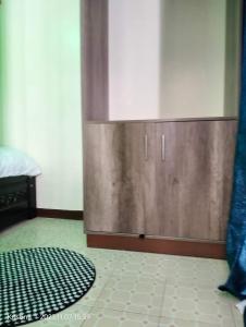 een houten kast in een kamer met een tapijt op de vloer bij Christie's apartments Buruburu in Nairobi