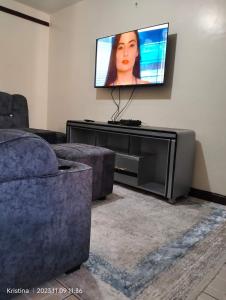 een woonkamer met een bank en een flatscreen-tv bij Christie's apartments Buruburu in Nairobi