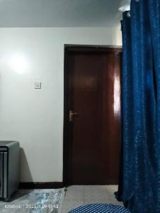 een deur met een blauw gordijn in een kamer bij Christie's apartments Buruburu in Nairobi