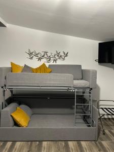 a gray couch with yellow pillows in a living room at Overwave Apartment in Kavála