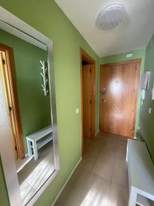 Habitación verde con espejo y puerta de madera. en Apartamento MARINA PLAYA, primera linea de mar en Blanes