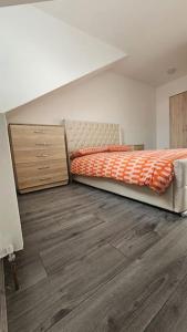 1 dormitorio con 1 cama y suelo de madera en Two Bedroom Apartment at Oldbury with side road parking, en Oldbury