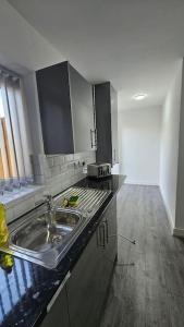 uma cozinha com um lavatório e uma bancada em Two Bedroom Apartment at Oldbury with side road parking em Oldbury