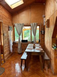 comedor con mesa de madera en una cabaña en CASA LA KOCHA, Cabin, Hostal en la Laguna de la Cocha, en El Encano