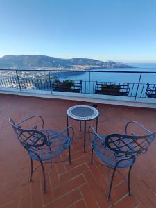 a patio with two chairs and a table on a balcony at Giardino 21 Marzo in Vico Equense
