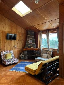 un soggiorno con letto e divano di CASA LA KOCHA, Cabin, Hostal en la Laguna de la Cocha a Encano