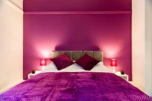 a purple bedroom with a bed with two red lamps at 3-Bed Apartment Central London - 15 Mins walk to Kings Cross by Seren Short Stays in London