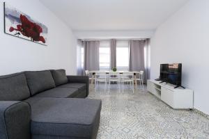 a living room with a couch and a tv and a table at NEW VALENCIA 2 Planetcostadorada in Salou