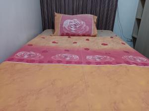uma cama com um cobertor rosa e uma almofada rosa em Toledo Jungle, Tropicana Garden City, Sumulong Highway, Marikina City, 1800 em Manilla
