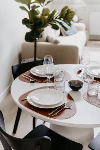 a white table with plates and wine glasses on it at Cathedral view from the bathtub in Antwerp +45 photos