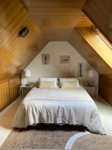 - une chambre mansardée avec un grand lit dans l'établissement Ty glaz, à Ploubazlanec