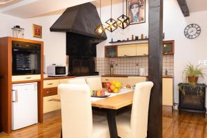 a kitchen with a table with chairs and a stove at Apartment Centar in Dubrovnik