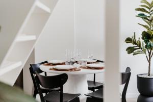 a dining room table with glasses and plates and chairs at Cathedral view from the bathtub in Antwerp
