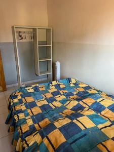 una manta azul y amarilla en una cama en una habitación en loft moderne en Yaundé