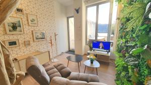 sala de estar con sofá y TV en Maison jacuzzi, hammam et sauna, en Saint-Vallier