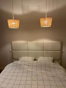 a bedroom with a bed with three lights above it at Appartement à 200 m de la mer in Merlimont