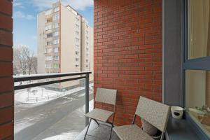 einen Balkon mit 2 Stühlen und einem Backsteingebäude in der Unterkunft Studio Wałowa 3 by Grand Apartments in Danzig